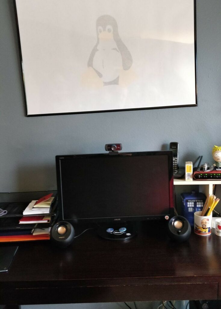 My desk at home with a LInux kernel poster above