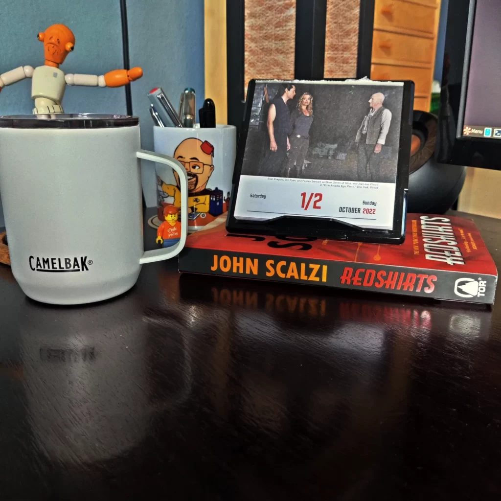 Desk calendar, mug with pens, coffee mug and John Scalzi's Redshirts novel