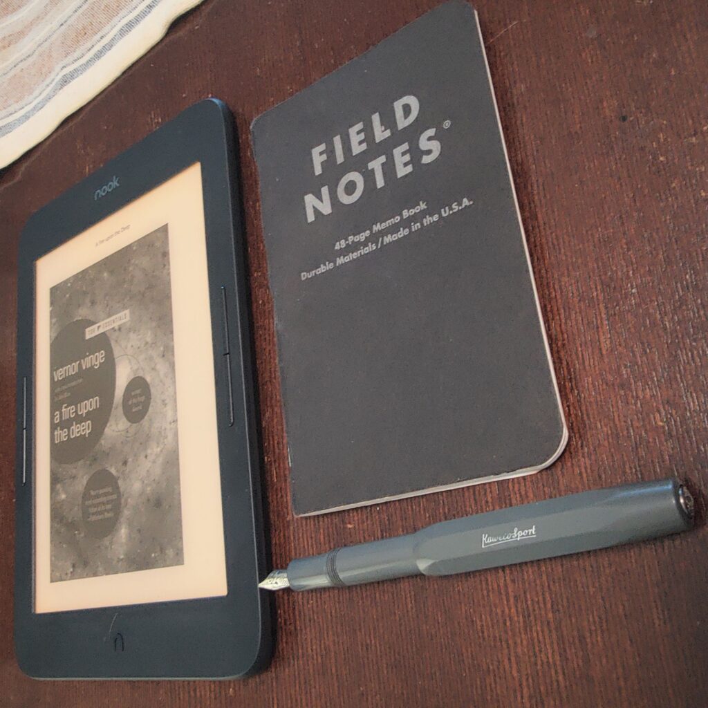 A Nook e-reader, Kaweco sport Fountain pen, Field Notes pocket notebook